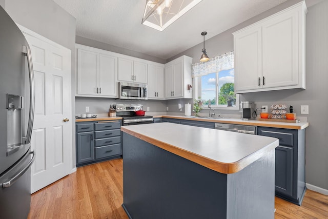 2418 Thrush St, Shakopee, MN 55379 - kitchen with stainless steel appliances, light wood-style floors, light countertops, and white cabinets