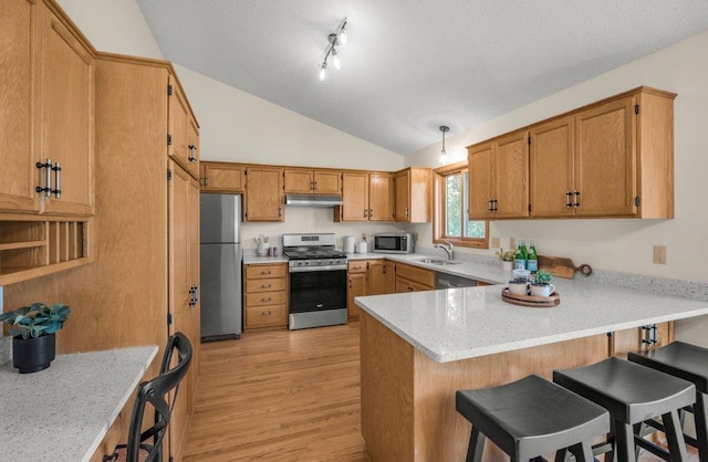2824 92nd Cres N, Brooklyn Park, MN 55443 - kitchen with stainless steel appliances, under cabinet range hood, a peninsula, vaulted ceiling, and light wood finished floors