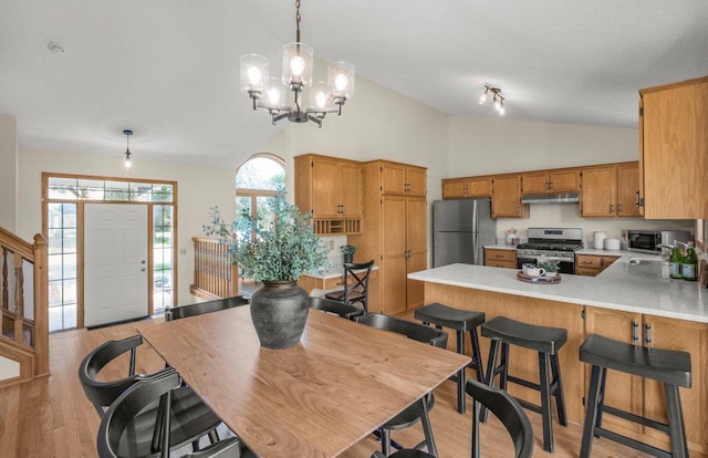 2824 92nd Cres N, Brooklyn Park, MN 55443 - kitchen featuring stainless steel appliances, vaulted ceiling, under cabinet range hood, a chandelier, and light countertops