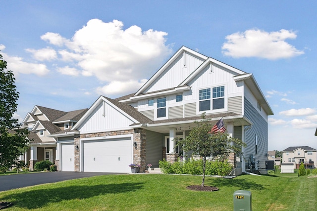 12745 39th St NE, Saint Michael, MN 55376 - view of front of house with board and batten siding, a front lawn, stone siding, and an attached garage