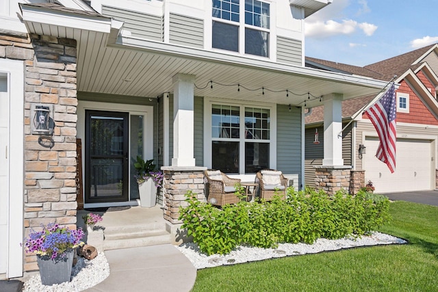 12745 39th St NE, Saint Michael, MN 55376 - doorway to property with stone siding, a porch, a garage, and asphalt driveway