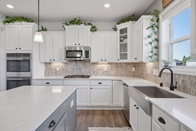 12745 39th St NE, Saint Michael, MN 55376 - kitchen with stainless steel appliances, dark wood-type flooring, light stone countertops, white cabinets, and hanging light fixtures