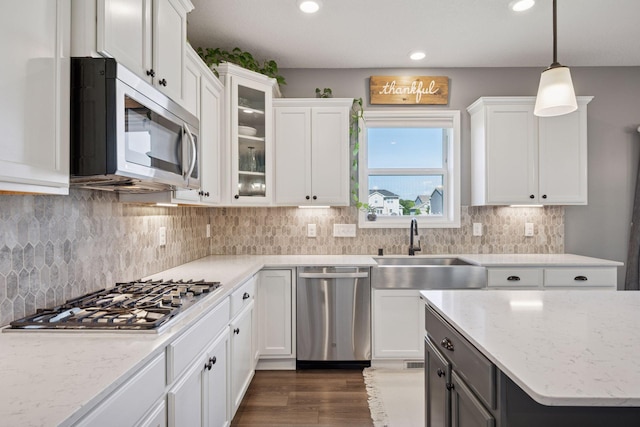 12745 39th St NE, Saint Michael, MN 55376 - kitchen with stainless steel appliances, white cabinetry, recessed lighting, hanging light fixtures, and glass insert cabinets