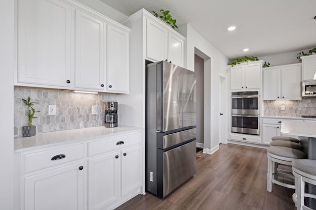 12745 39th St NE, Saint Michael, MN 55376 - kitchen featuring appliances with stainless steel finishes, light countertops, white cabinets, tasteful backsplash, and recessed lighting