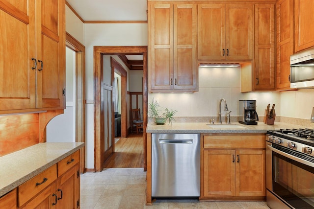 3343 Humboldt Ave S, Minneapolis, MN 55408 - kitchen with appliances with stainless steel finishes, crown molding, and brown cabinetry