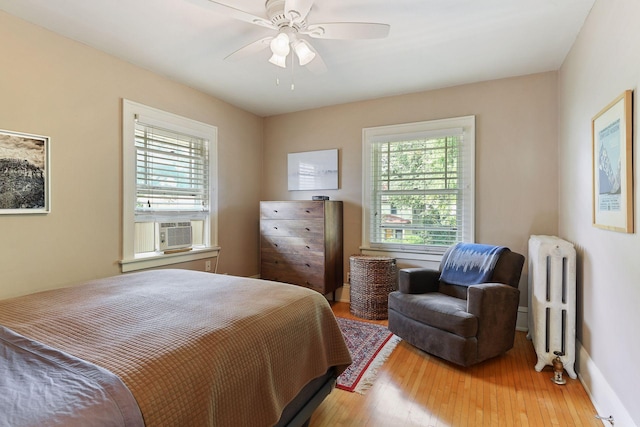 3343 Humboldt Ave S, Minneapolis, MN 55408 - bedroom featuring radiator heating unit, multiple windows, wood finished floors, and cooling unit