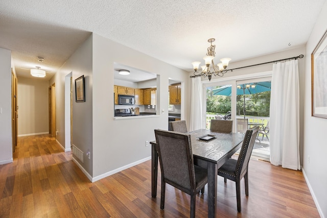 11810 191 1/2 Ave NW, Elk River, MN 55330 - dining area featuring a chandelier, wood finished floors, and a textured ceiling