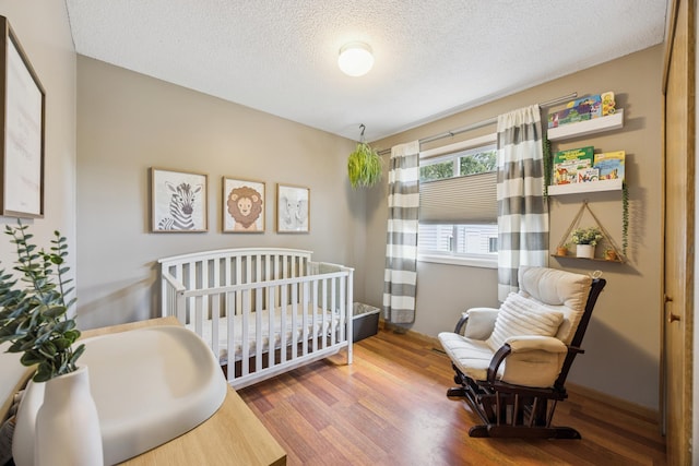 11810 191 1/2 Ave NW, Elk River, MN 55330 - bedroom with wood finished floors, a textured ceiling, and a nursery area