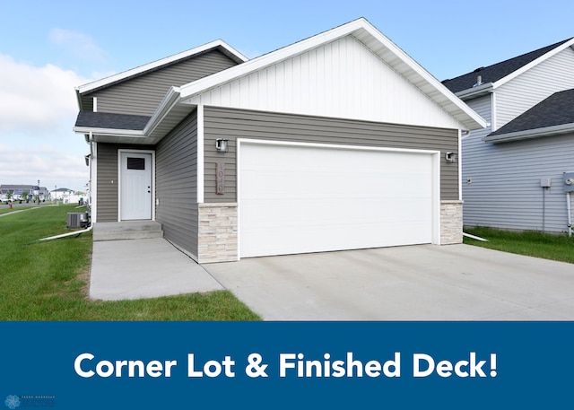 1040 Barnes Dr, West Fargo, ND 58078 - view of front of home featuring stone siding, a garage, driveway, and a front lawn