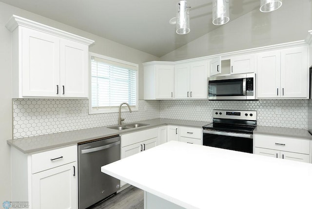 1040 Barnes Dr, West Fargo, ND 58078 - kitchen featuring appliances with stainless steel finishes, vaulted ceiling, white cabinets, and light countertops