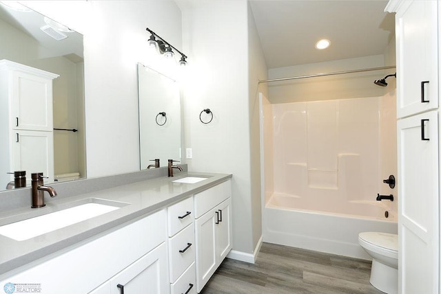 1040 Barnes Dr, West Fargo, ND 58078 - full bathroom featuring double vanity, recessed lighting, shower / bath combination, and wood finished floors