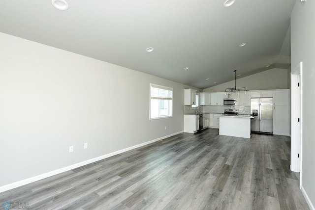 1040 Barnes Dr, West Fargo, ND 58078 - unfurnished living room featuring wood finished floors, vaulted ceiling, and recessed lighting