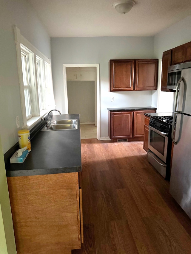663 Smith Ave S, Saint Paul, MN 55107 - kitchen featuring stainless steel appliances, wood finished floors, and dark countertops