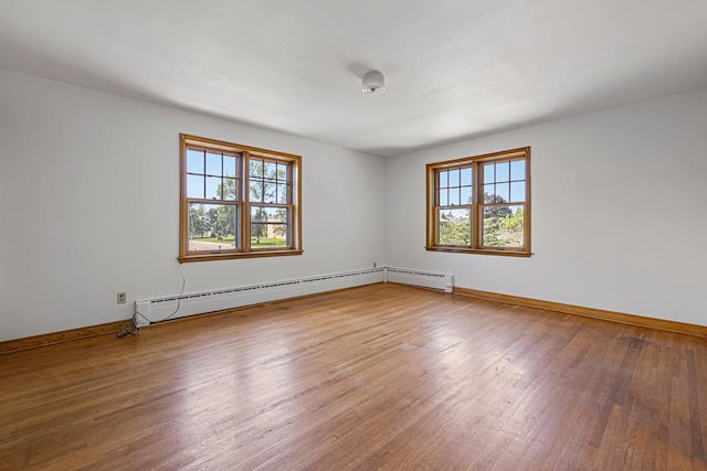440 6th St, Lafayette, MN 56054 - unfurnished room featuring plenty of natural light, hardwood / wood-style floors, and a baseboard heating unit