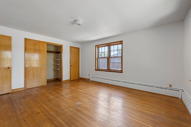 440 6th St, Lafayette, MN 56054 - unfurnished bedroom featuring multiple closets, baseboard heating, and light wood finished floors