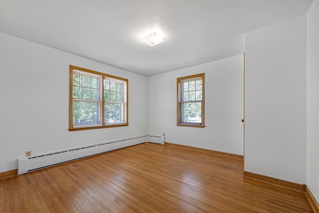 440 6th St, Lafayette, MN 56054 - empty room featuring a baseboard heating unit, plenty of natural light, and wood finished floors