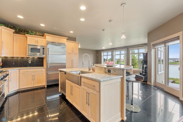 1811 7th St, Fargo, ND 58078 - kitchen with built in appliances, granite tiled floors, recessed lighting, light brown cabinetry, and a kitchen bar