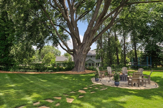 5815 Howards Point Rd, Shorewood, MN 55331 - view of green lawn with a trampoline, a patio area, and a fire pit
