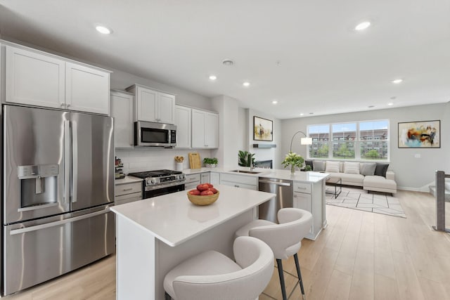 7407 E Ramsey Pkwy NW, Ramsey, MN 55303 - kitchen featuring appliances with stainless steel finishes, a peninsula, light countertops, recessed lighting, and light wood finished floors