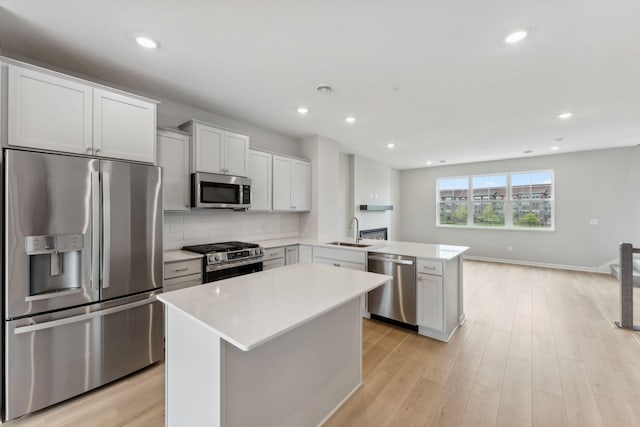 7407 E Ramsey Pkwy NW, Ramsey, MN 55303 - kitchen featuring appliances with stainless steel finishes, a peninsula, light countertops, backsplash, and light wood-type flooring