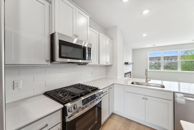 7407 E Ramsey Pkwy NW, Ramsey, MN 55303 - kitchen with stainless steel appliances, light wood-type flooring, light countertops, recessed lighting, and backsplash