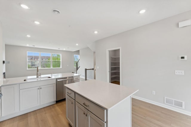 7407 E Ramsey Pkwy NW, Ramsey, MN 55303 - kitchen featuring stainless steel dishwasher, light wood-type flooring, light countertops, recessed lighting, and a center island
