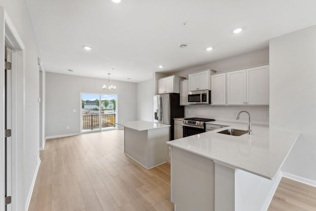 7407 E Ramsey Pkwy NW, Ramsey, MN 55303 - kitchen featuring appliances with stainless steel finishes, a chandelier, light wood-style flooring, tasteful backsplash, and light countertops