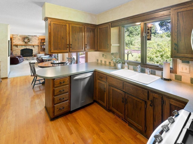 461 Dudley Ave, Shoreview, MN 55126 - kitchen featuring stainless steel dishwasher, a peninsula, light wood-type flooring, a brick fireplace, and open floor plan