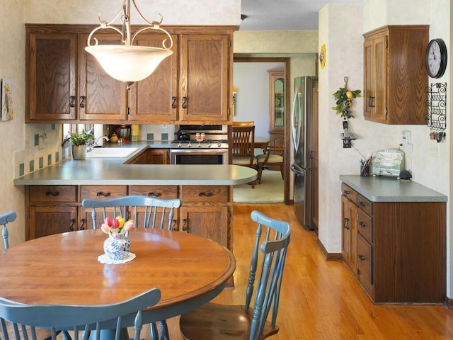 461 Dudley Ave, Shoreview, MN 55126 - kitchen featuring appliances with stainless steel finishes, light wood finished floors, brown cabinetry, and light countertops