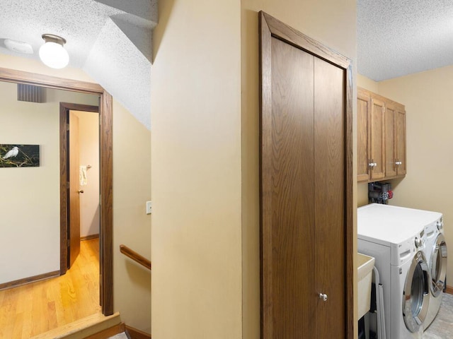 461 Dudley Ave, Shoreview, MN 55126 - laundry room with a textured ceiling, cabinet space, washer and clothes dryer, and light wood-type flooring