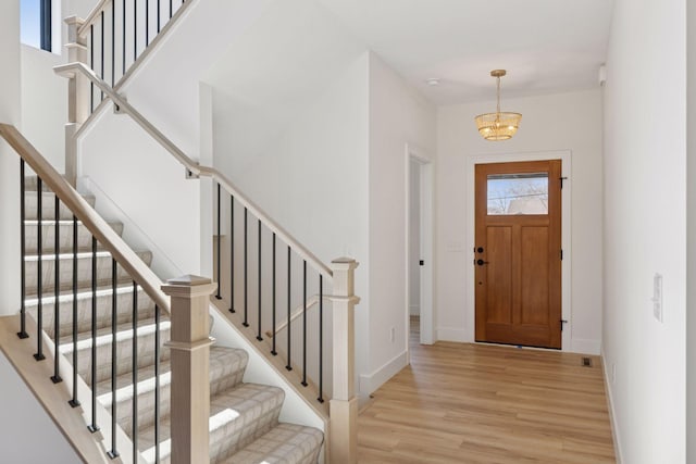 987 Island Lake Ave, Shoreview, MN 55126 - foyer featuring light wood finished floors, a chandelier, and stairway