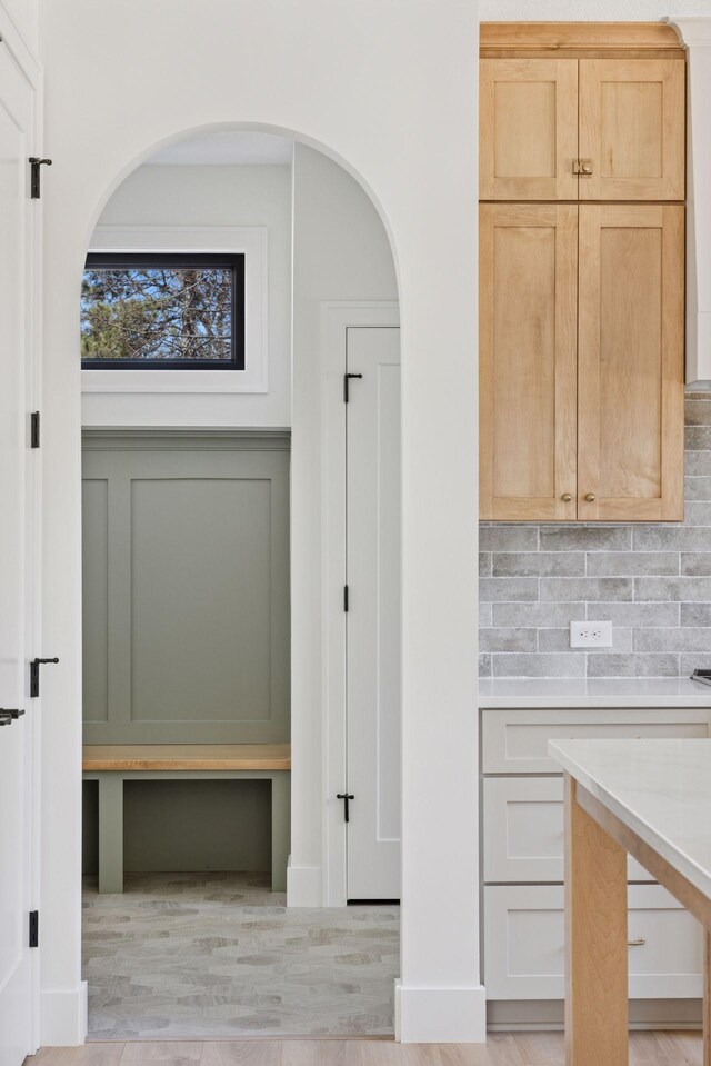 987 Island Lake Ave, Shoreview, MN 55126 - kitchen with light countertops, backsplash, light wood-style floors, light brown cabinetry, and arched walkways