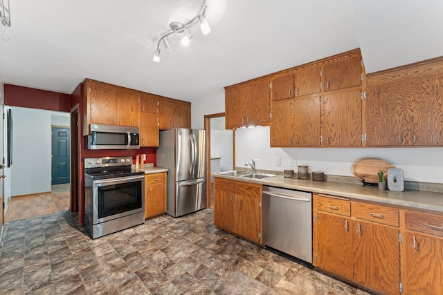 1111 Edgewater Ave, Arden Hills, MN 55112 - kitchen featuring appliances with stainless steel finishes, brown cabinetry, stone finish flooring, and light countertops