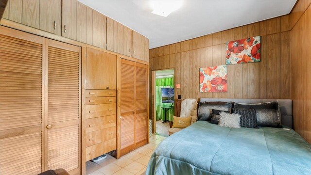 114 Fairview Ave NW, Long Prairie, MN 56347 - bedroom featuring light tile patterned flooring, wood walls, and a closet