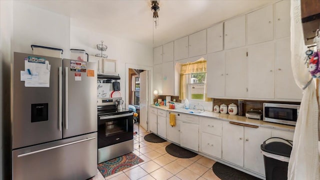 114 Fairview Ave NW, Long Prairie, MN 56347 - kitchen featuring stainless steel appliances, light countertops, white cabinetry, light tile patterned floors, and tasteful backsplash