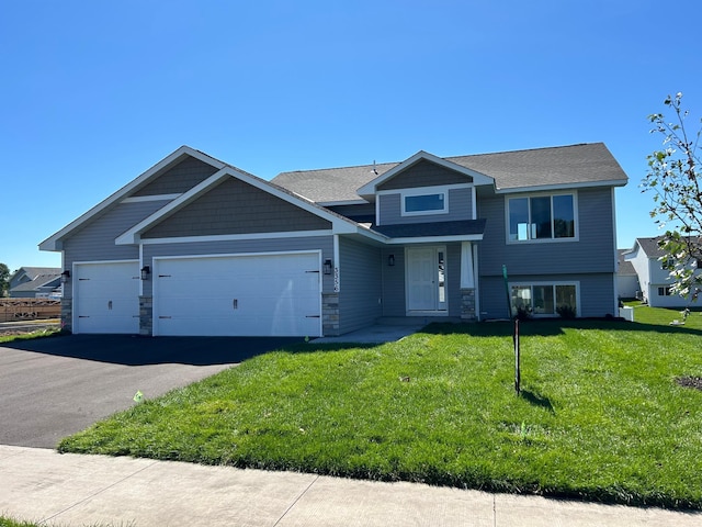 3454 237th Ave NW, Saint Francis, MN 55070 - view of front facade with an attached garage, a front yard, asphalt driveway, roof with shingles, and stone siding