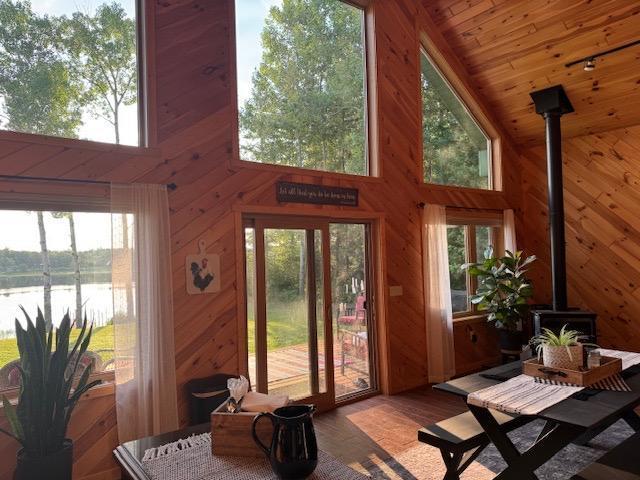 1415 Riverside Dr NW Unit 1415, Baudette, MN 56623 - sunroom featuring a wood stove, a water view, and healthy amount of natural light