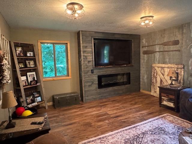 1415 Riverside Dr NW Unit 1415, Baudette, MN 56623 - living room with a textured ceiling, wood finished floors, and a large fireplace