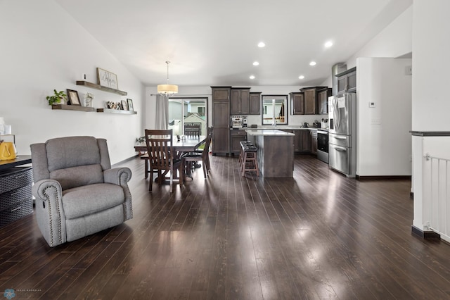 6028 59th Ave S, Fargo, ND 58104 - kitchen with stainless steel refrigerator with ice dispenser, open floor plan, dark brown cabinetry, light countertops, and a kitchen island