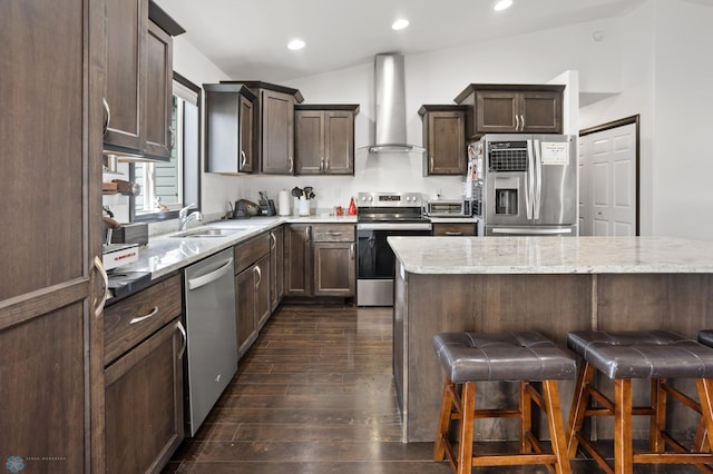 6028 59th Ave S, Fargo, ND 58104 - kitchen featuring wall chimney exhaust hood, stainless steel appliances, dark wood-type flooring, a kitchen bar, and light stone counters