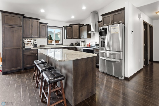 6028 59th Ave S, Fargo, ND 58104 - kitchen with stainless steel appliances, wall chimney exhaust hood, dark brown cabinets, a breakfast bar, and a kitchen island
