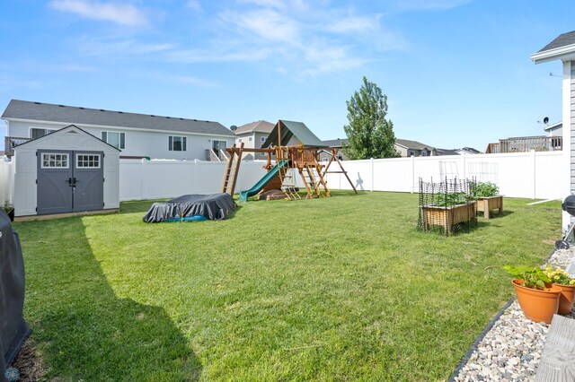 6028 59th Ave S, Fargo, ND 58104 - fenced backyard with a garden, a playground, and a storage unit