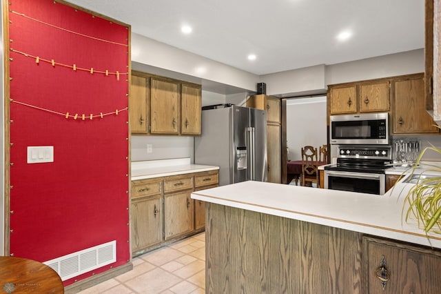 21 35th Ave NE, Fargo, ND 58102 - kitchen with stainless steel appliances, light countertops, recessed lighting, a peninsula, and brown cabinets