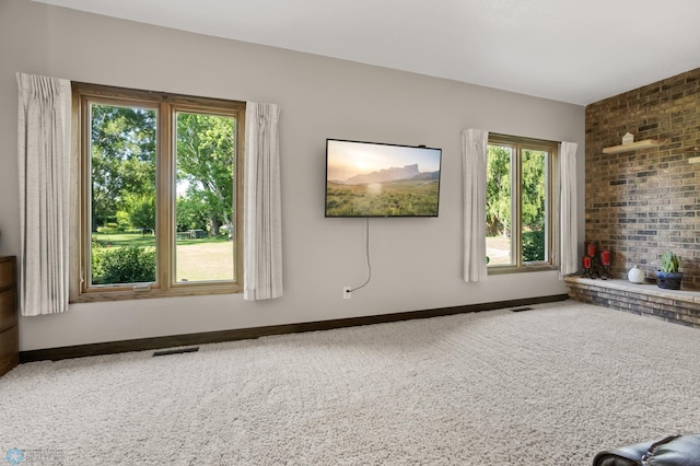 21 35th Ave NE, Fargo, ND 58102 - unfurnished living room with carpet, plenty of natural light, and brick wall