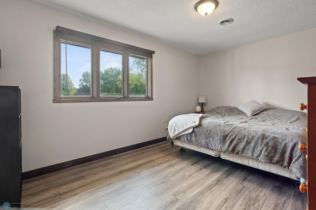 21 35th Ave NE, Fargo, ND 58102 - bedroom with wood finished floors and a textured ceiling