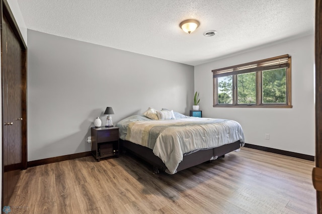 21 35th Ave NE, Fargo, ND 58102 - bedroom featuring a textured ceiling and wood finished floors