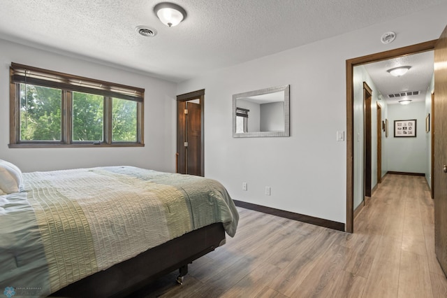 21 35th Ave NE, Fargo, ND 58102 - bedroom featuring light wood-style flooring and a textured ceiling