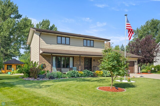 21 35th Ave NE, Fargo, ND 58102 - traditional-style house with a porch, a front yard, an attached garage, and driveway