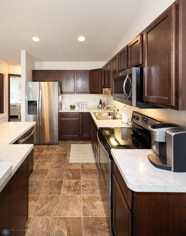 34 Cedar Dr, Mapleton, ND 58059 - kitchen with stainless steel appliances, dark brown cabinets, light countertops, a textured ceiling, and recessed lighting