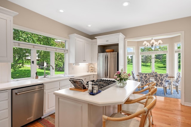 4803 Chantrey Pl, Minnetonka, MN 55345 - kitchen with stainless steel appliances, a chandelier, light countertops, a center island, and white cabinetry
